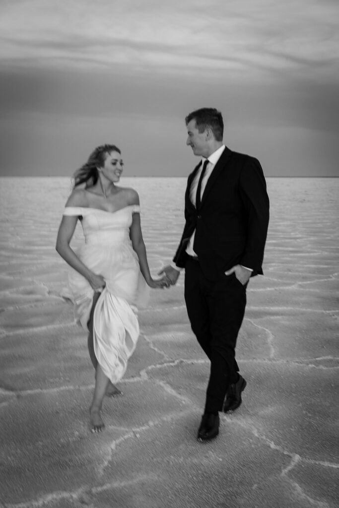 Couple stands hand in hand at the Bonneville Salt Flats during their Utah elopement