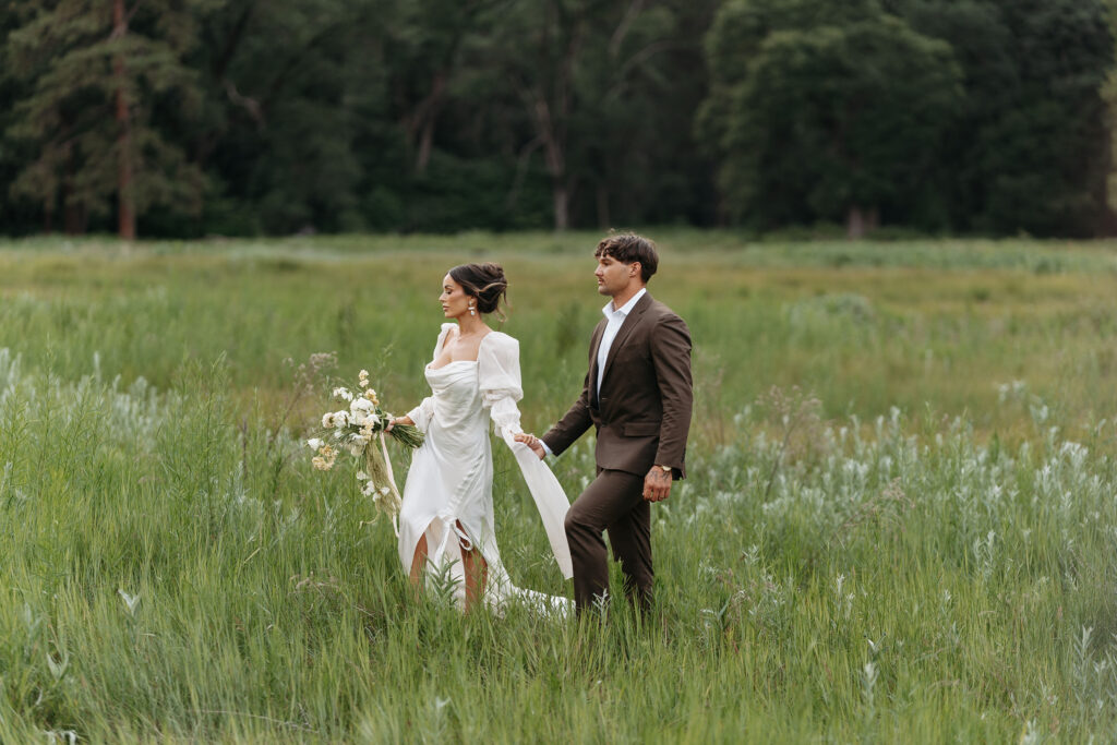 Scenic view of couple surrounded by tall grass and forest backdrop