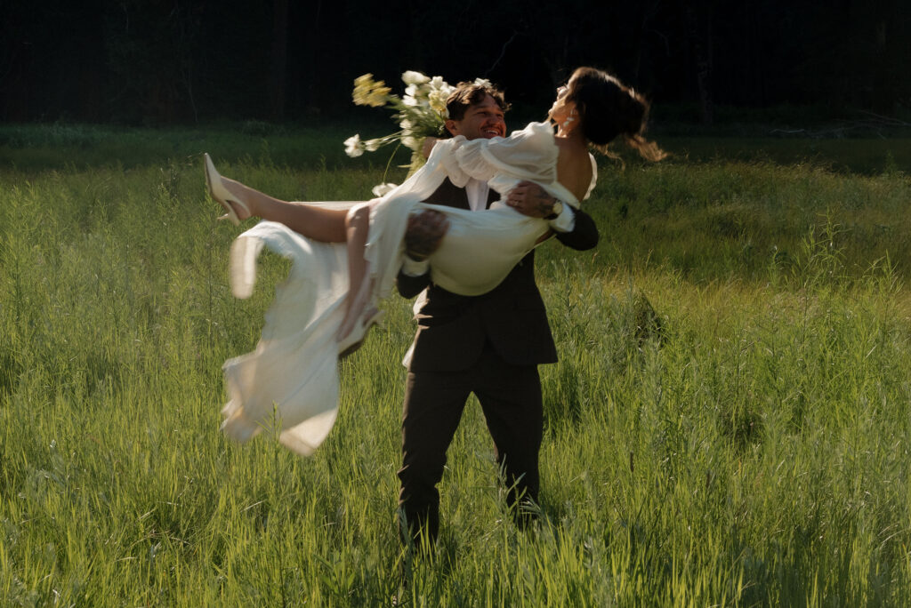 Bride and groom holding each other in an open meadow