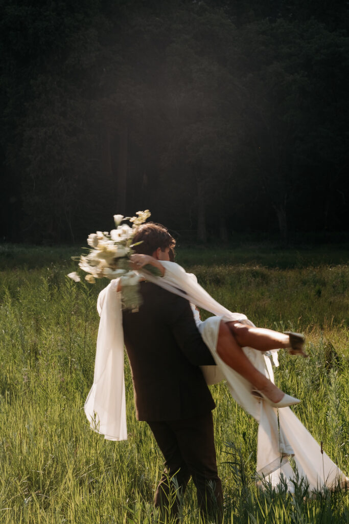 Couple eloping in Yosemite Valley meadow with towering cliffs and waterfall backdrop