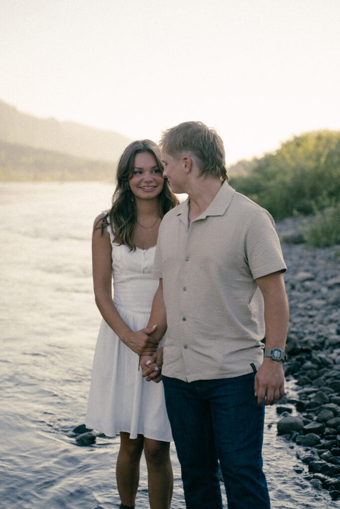 Couple looking at each other while holding hands during outdoor photo shoot