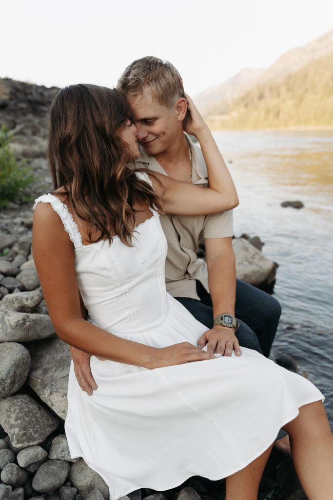 Bride and groom-to-be sharing a tender moment by the river