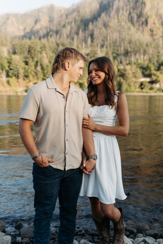 Couple holding hands by the Columbia River Gorge during engagement session