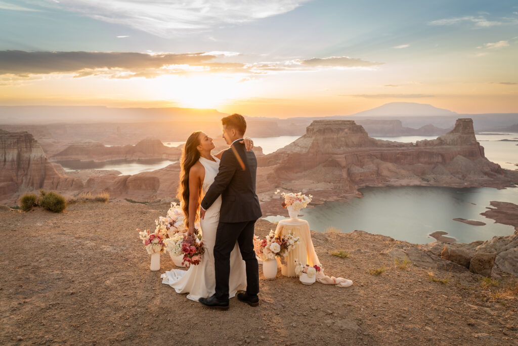 Couple celebrating with the lake and mesas stretching behind them.