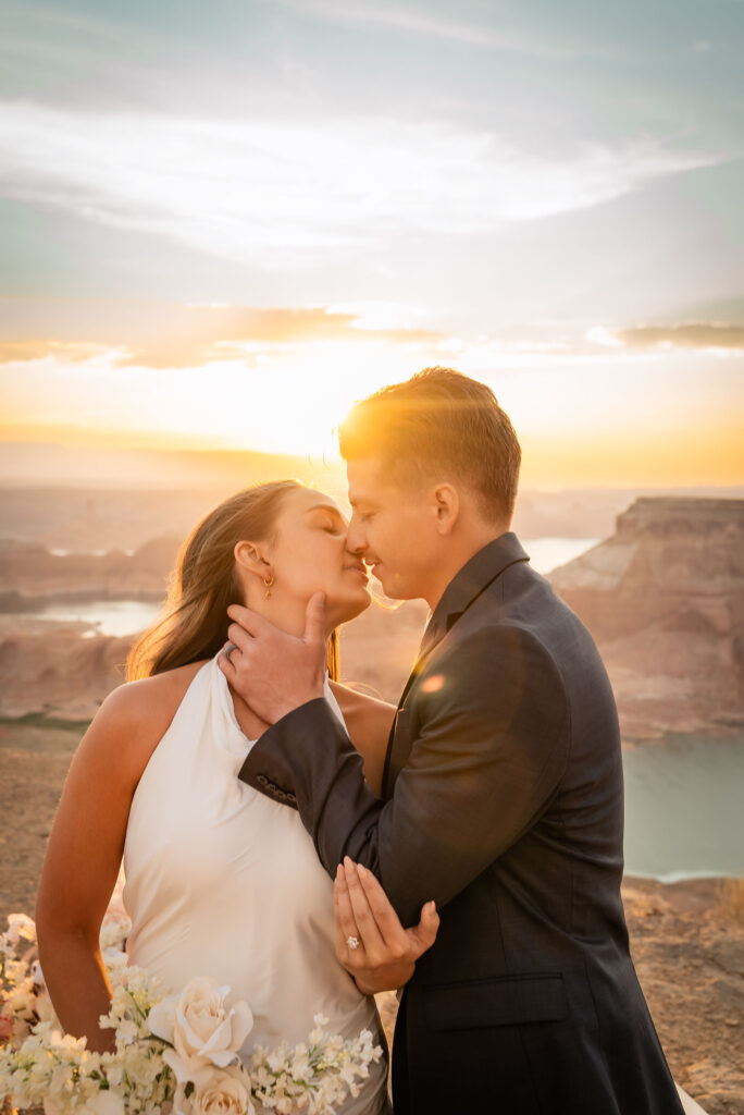 Elopement couple holding each other on remote desert terrain.