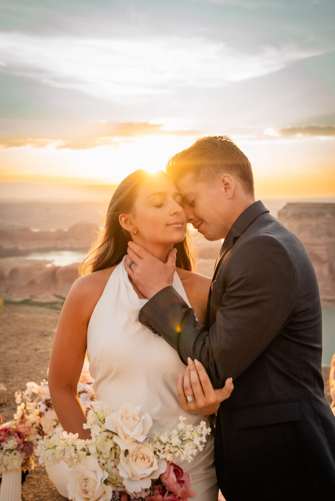 Bride and groom lit by soft golden hour light with canyon backdrop.