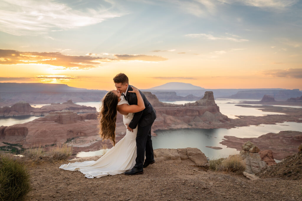 Bride and groom lit by soft golden hour light with canyon backdrop.