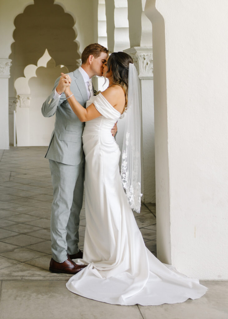 Candid kiss between bride and groom after their wedding ceremony