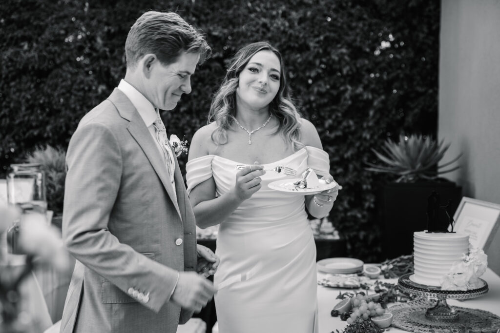 Bride smiling at the camera while enjoying wedding cake during the reception