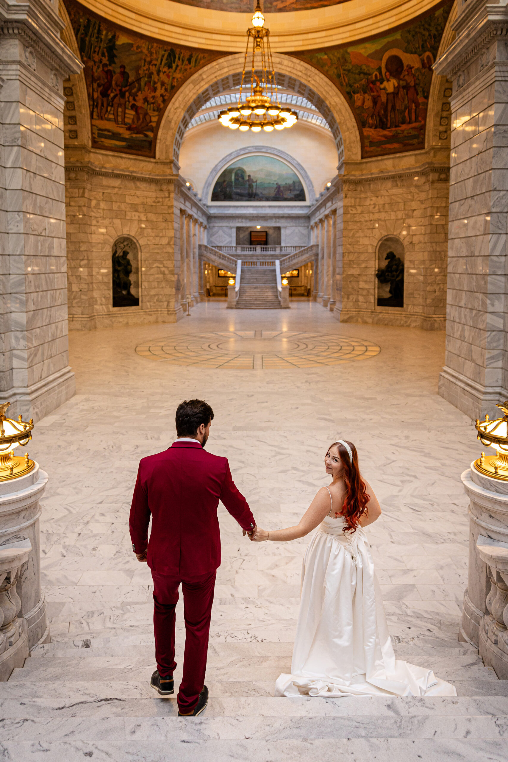 Bride and groom walking down the grand staircase inside the Utah State Capitol during their Salt Lake City courthouse elopement.