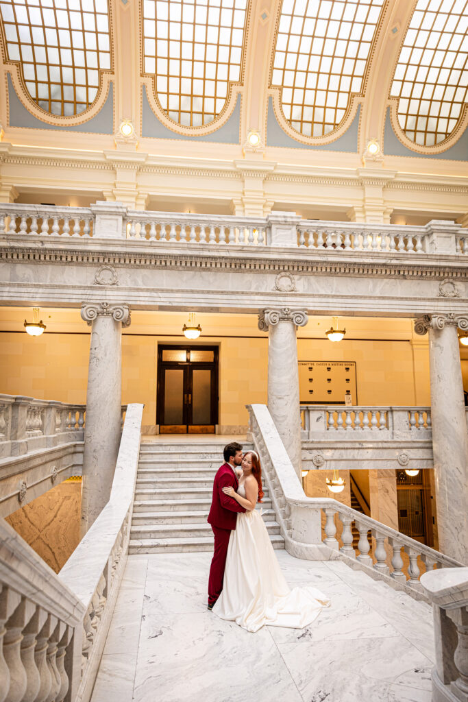 Bride and groom posing beneath the grand dome — cinematic Utah State Capitol elopement session.