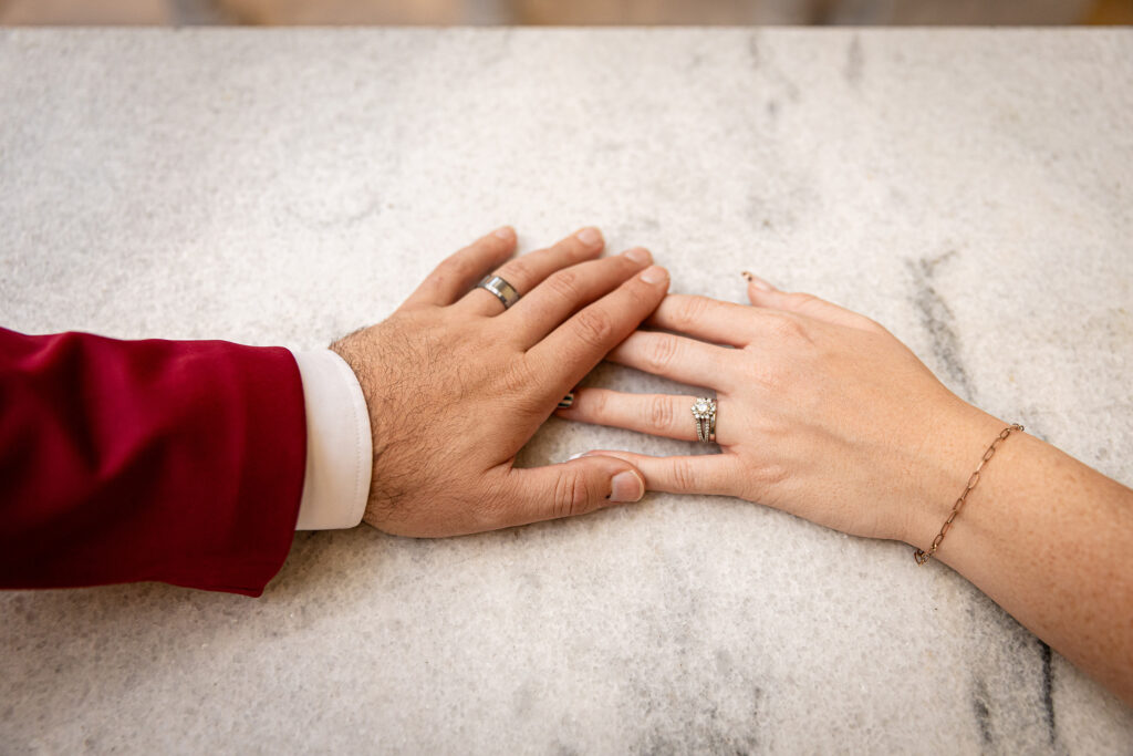 Close-up of couple’s hands wearing wedding rings during their Utah State Capitol courthouse elopement.